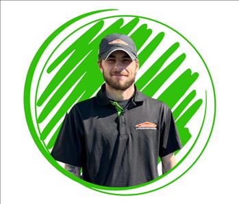 Man leaning against green SERVPRO® van to pose for photo